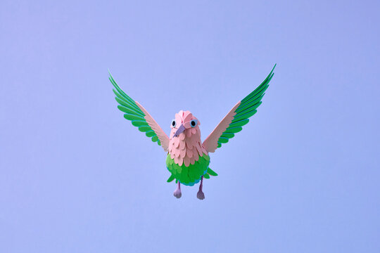 Paper hummingbird flying on blue background