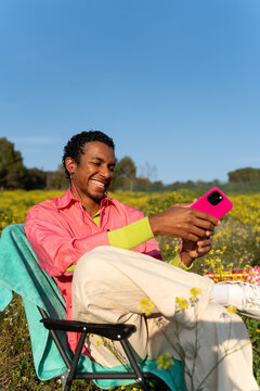 Man Enjoys Using Smartphone in a Field