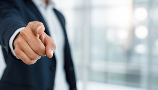 You're Fired, You're Hired: A person in a suit points directly at the camera, an ambiguous gesture that can signify hiring or firing in a business context.
