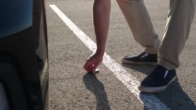 Unsuspecting man finds lost USB thumb drive on ground illustrating malicious USB drop attack - Cybersecurity Information Technology Concept