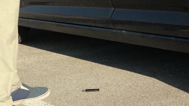 Unsuspecting man finds lost USB thumb drive on ground illustrating malicious USB drop attack - Cybersecurity Information Technology Concept