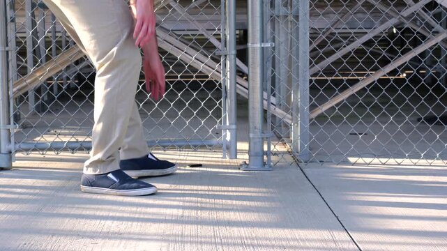 Unsuspecting man finds lost USB thumb drive on ground illustrating malicious USB drop attack - Cybersecurity Information Technology Concept