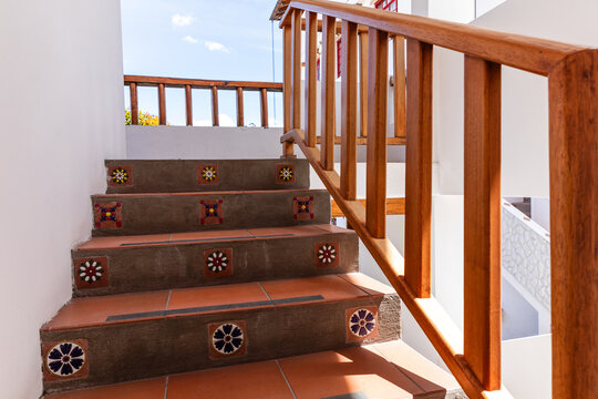 panish colonial style staircase with terracotta tiles and wooden railing