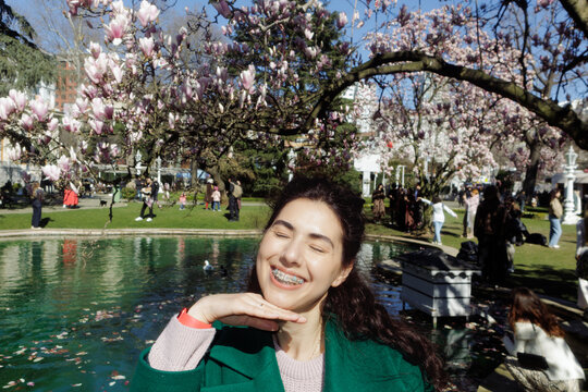 portrait of a woman in a park near a magnolia tree