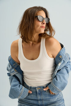Model Poses in Casual Outfit Inside a Studio With Light Backdrop