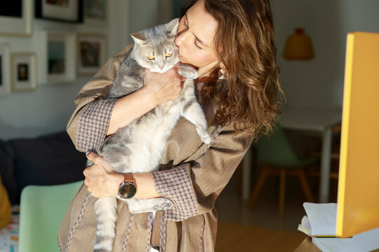 Woman Holds Cat Close in Cozy Living Room Setting