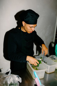 A chef sanitizing cilantro in a kitchen
