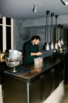 Professional chef shucking clams in the kitchen of a restaurant