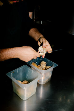 Tight close-up of an unidentified chef shucking clams