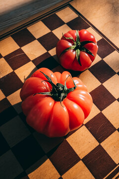 Two red tomatoes on a chessboard