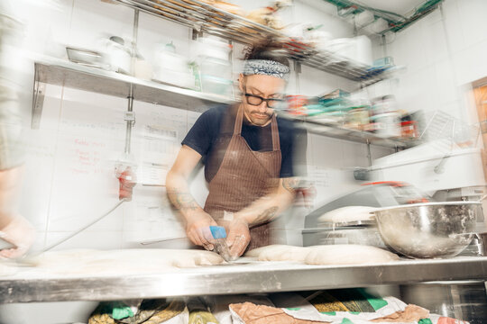 Baker preparing dough in fast-paced commercial kitchen