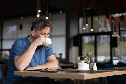 Man Drinking Coffee Alone at Restaurant