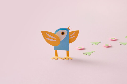 Paper spring craft bird with flowers on pink