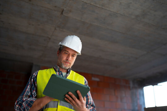 Worker checks tablet on construction site