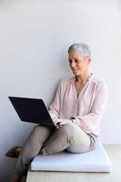 Businesswoman works on a laptop while sitting at ease