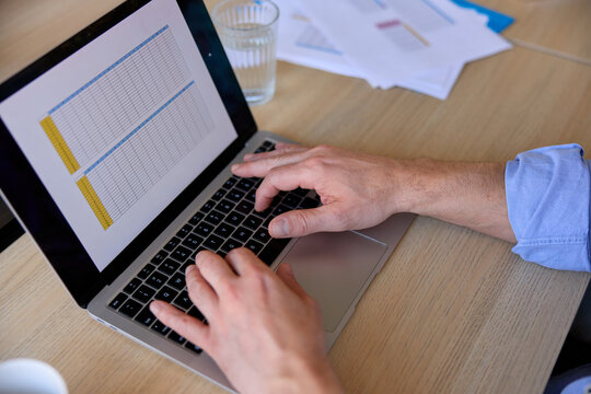 Anonymous man operates on a laptop