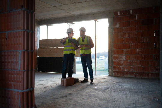 Workers discuss plans at the site