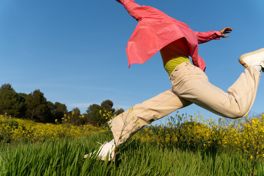 Person Jumps in a Field Under a  Blue Sky