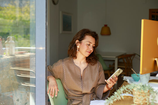 Latina Freelancer Checking Smartphone