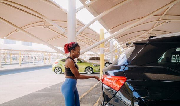 A woman takes out a gym bag from the car
