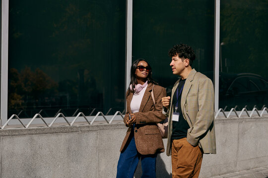 Business colleagues walking and talking outside office building