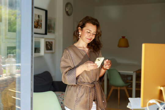 Woman Uses Smartphone at Home in the Morning Light