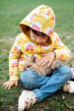 Girl holding a cute little rabbit in her arms. 