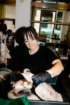 Female chef preparing fresh cuttlefish in a fine-dining restaurant