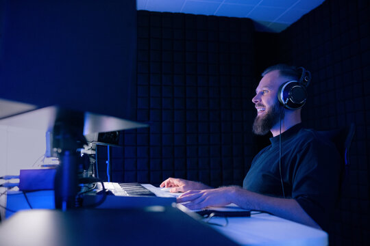 Music Producer Works in Sound Studio With Blue Lighting at Night