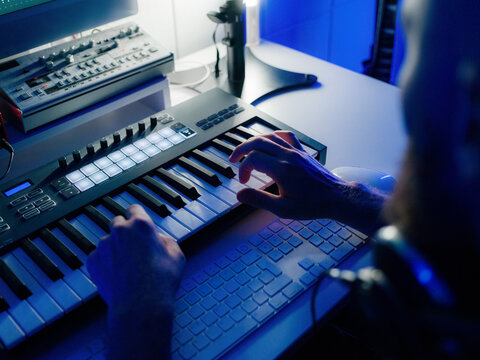 Musician Plays Midi Keyboard in Home Studio at Night