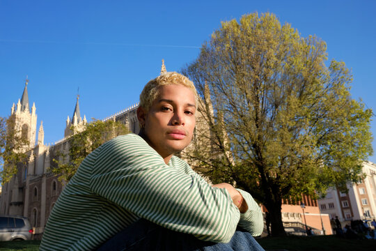 Person sitting on grass near historic cathedral in city park