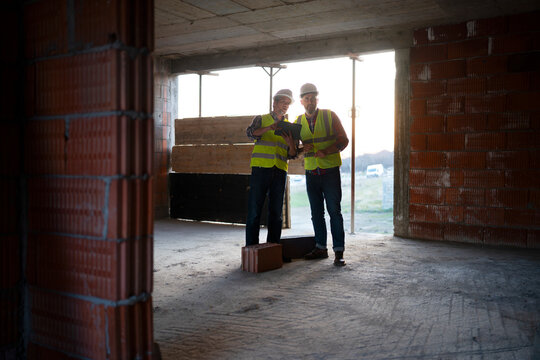 Construction workers review plans at job site