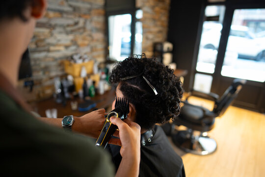 Cutting hair in a barber shop with a client seated