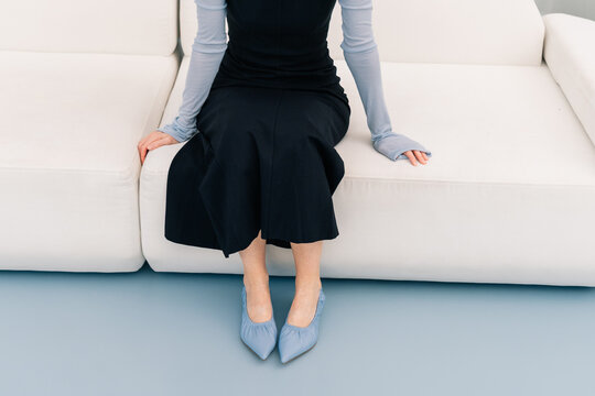 Woman Sitting on Sofa in Minimal Fashion Composition