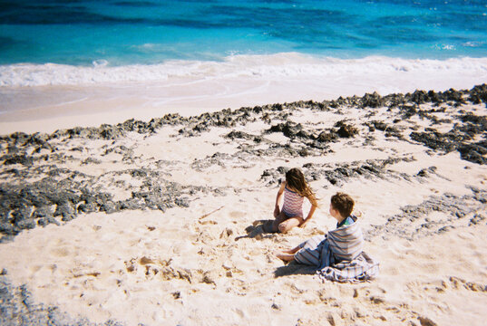 Children play on a sandy beach in the Bahamas