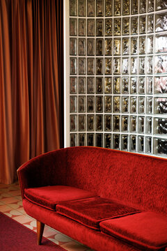 Red velvet sofa with glass block wall