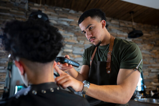 Barber giving haircut in shop during day time