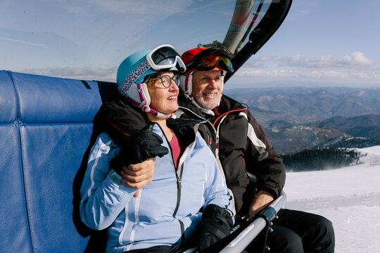 Couple Enjoying Ski Lift Ride in Winter