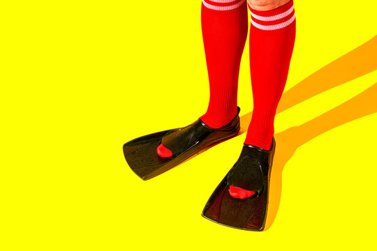 a man in red socks wears black diving fins indoors