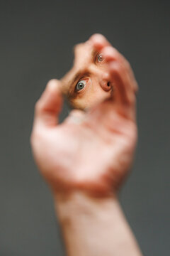 Person Looks Through a Broken Mirror Holding a Fragment in Hand