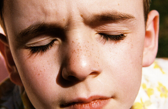 Close up of child's face with freckles on skin
