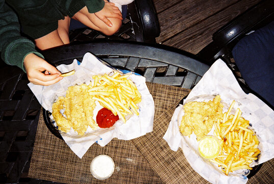Plates of chicken fingers and french fries at restaurant