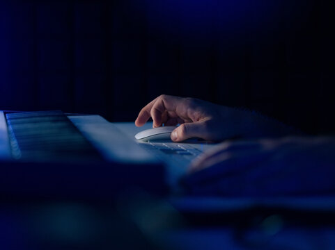 Hand Operates Computer Mouse in Dark Room During Night Work