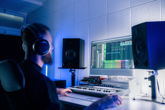 Musician Works on Music Production in a Home Studio at Night