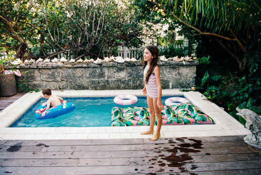 Kids play in outdoor pool with inflatable toys