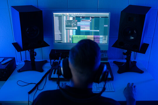 Music Producer Works on Audio Project in Studio at Night