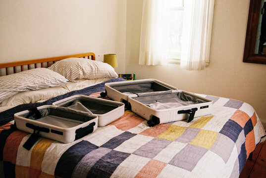Two suitcases open on bed at home, ready to pack for vacation travel