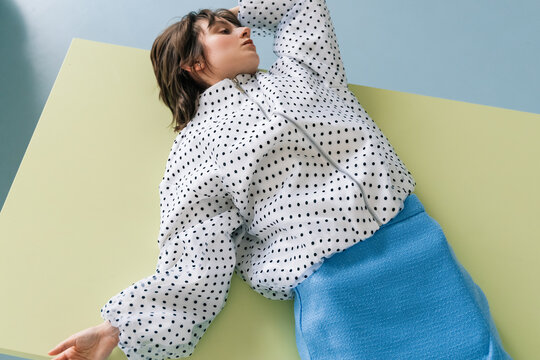 Contemporary fashion look with polka dot blouse and blue skirt