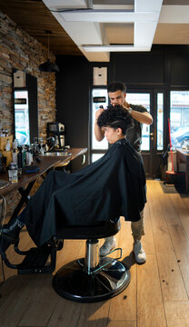 Barber cuts hair in a modern shop in the city