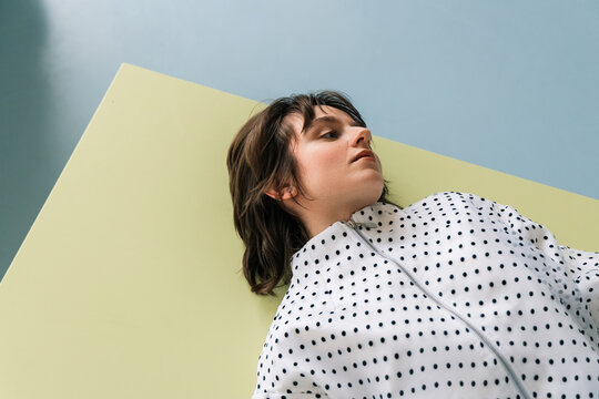 Woman in Polka Dot Blouse Lying on Table